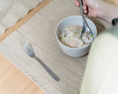 Close-up of a warm and inviting Thai home breakfast setting with rice porridge and a glass of fresh water